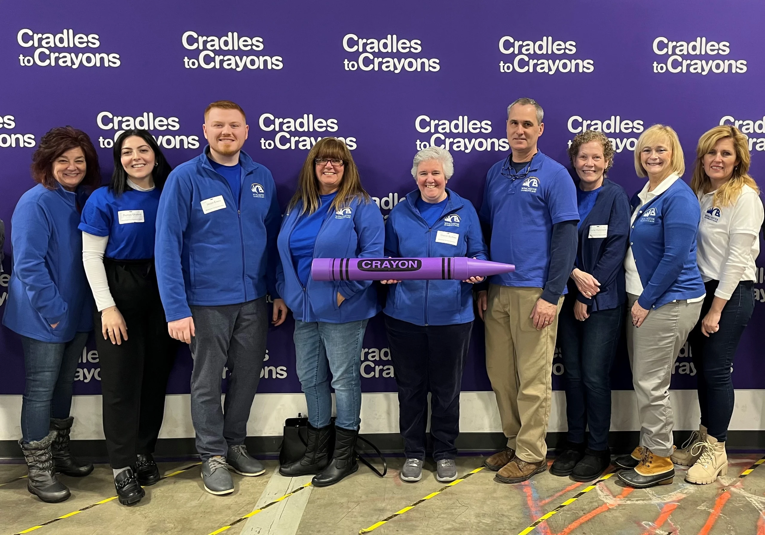 Group of Bankers in front of Cradles for Crayons Backdrop