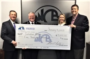 Four people pictured with a big check.