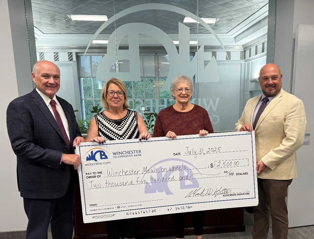 Chris and Mark with big check and women from Meals on Wheels