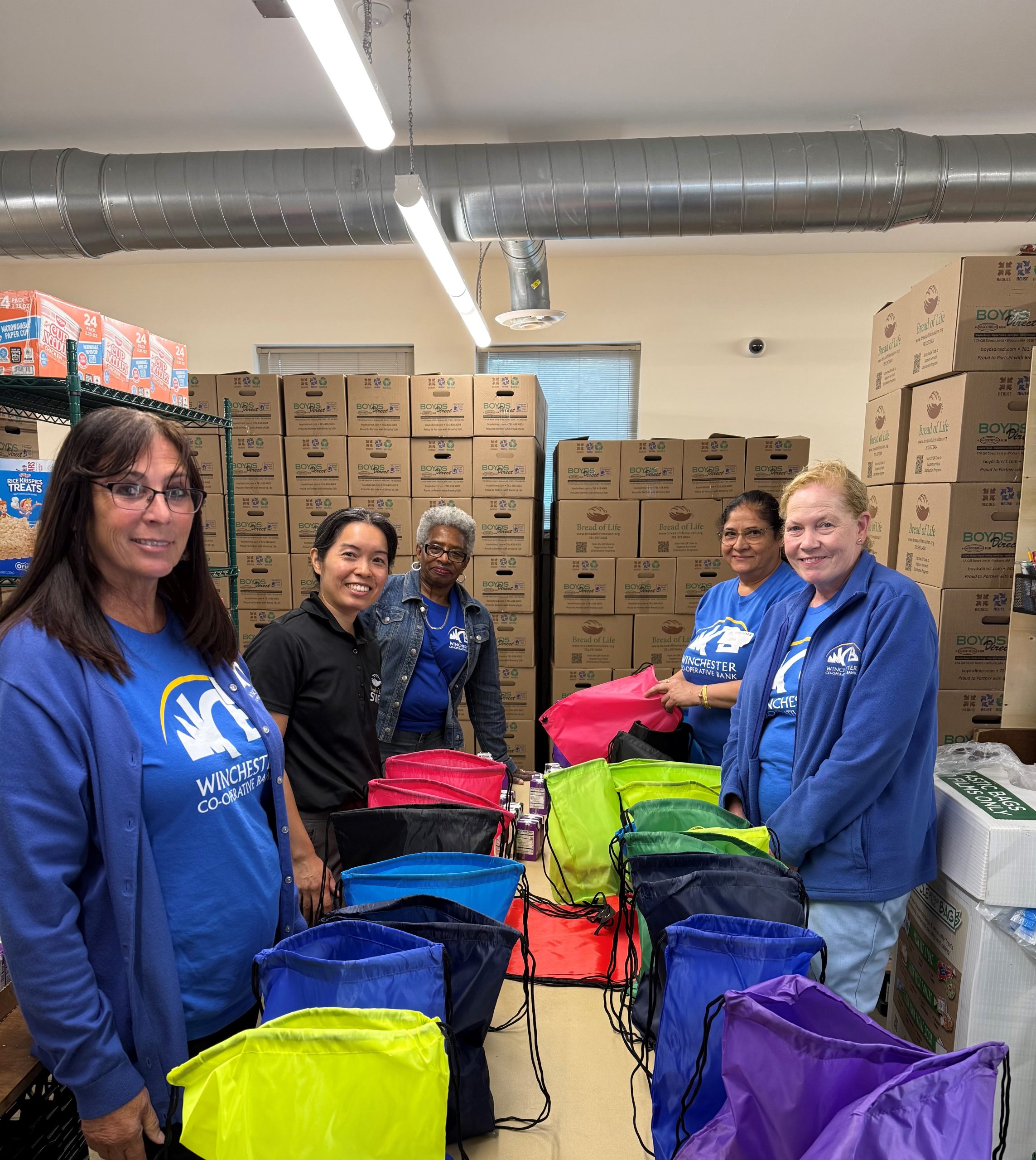 women standing in front of colored bags