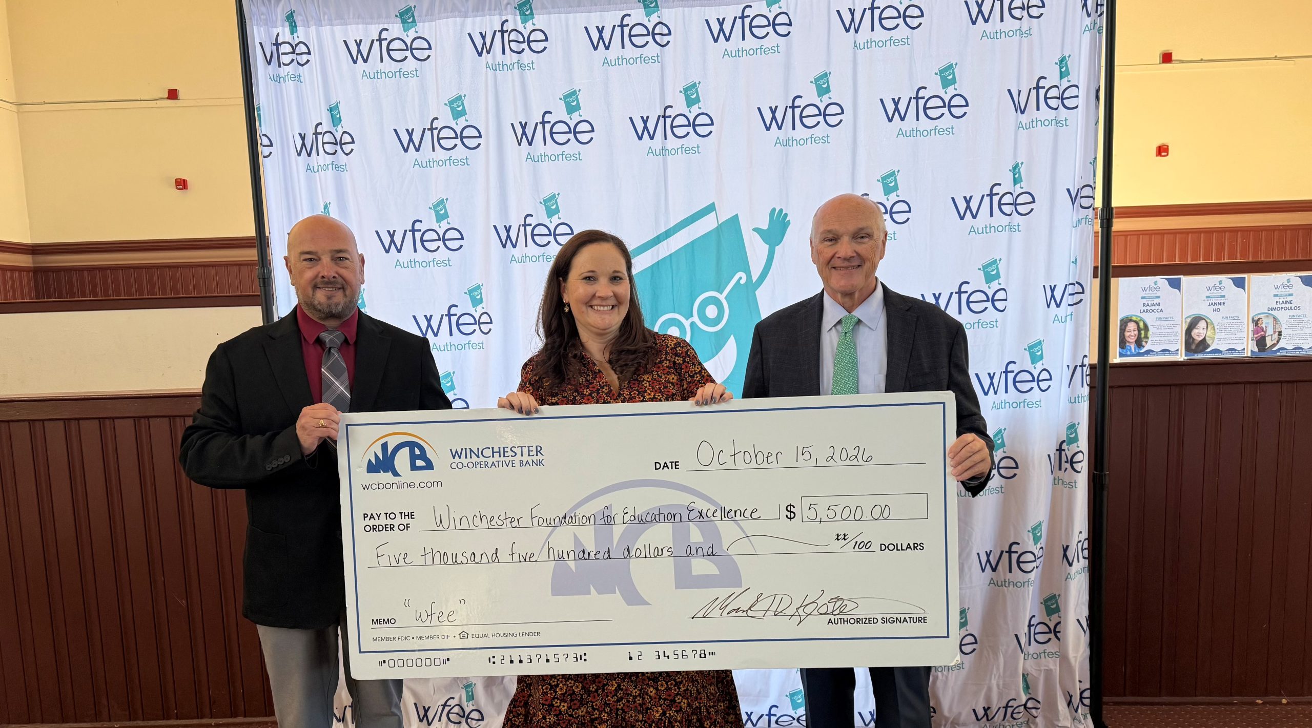 Chris and Mark holding check with Maggie in the middle