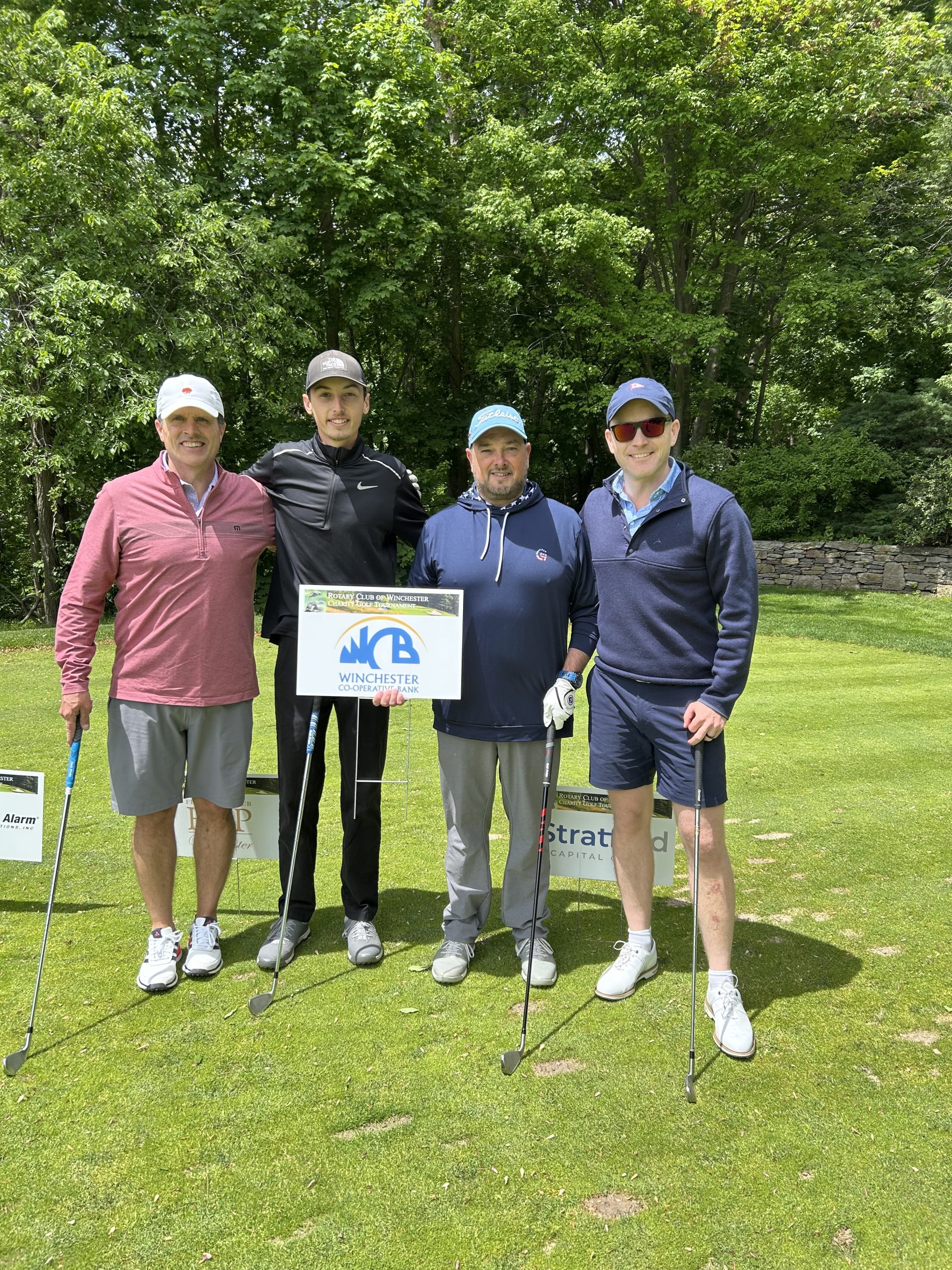 4 golfers behind Winchester Co-operative Bank sign