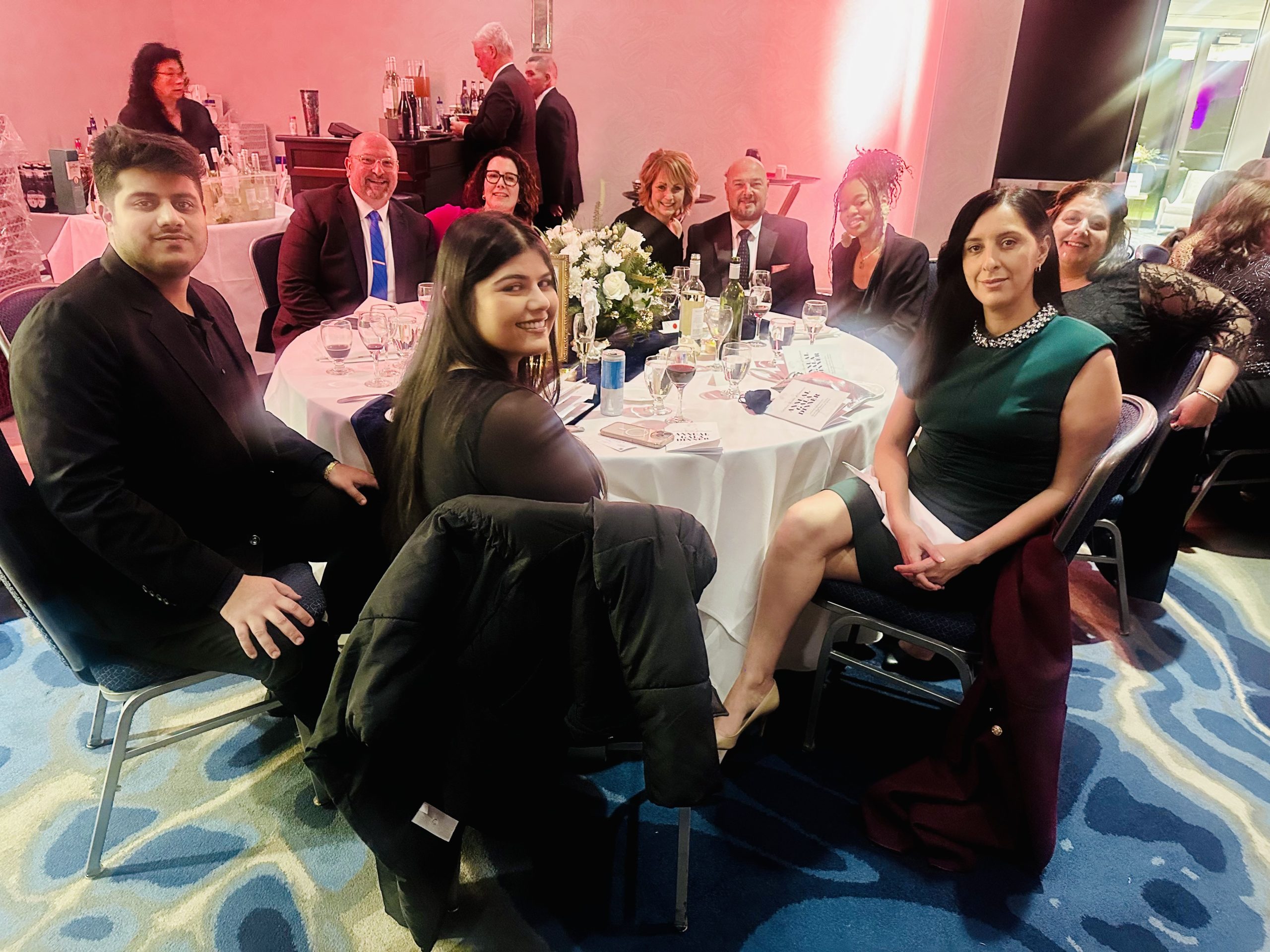 employees and guest at gala sitting at table