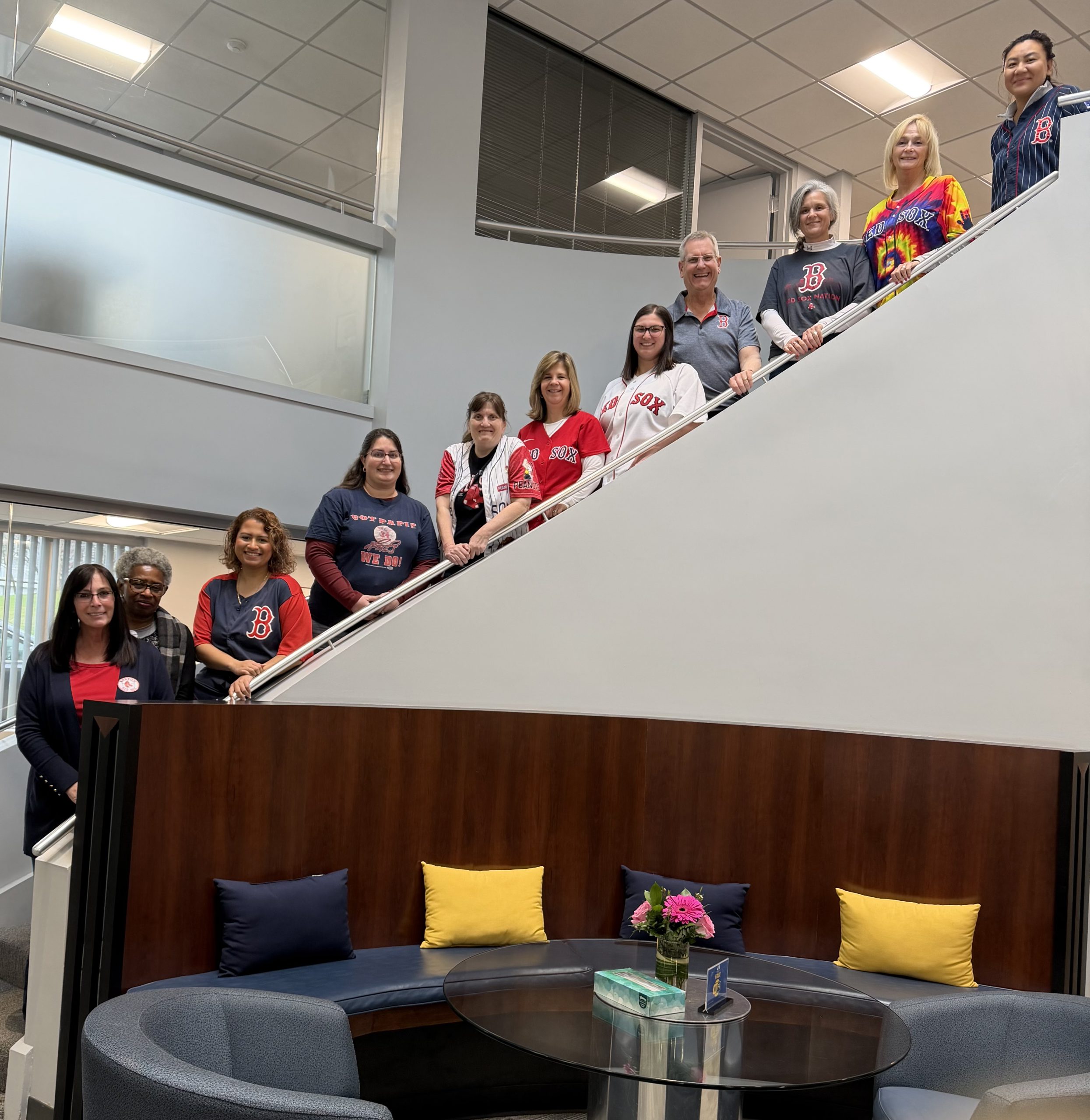 Group of people standing on stairs with Red Sox gear in Red, blue and white