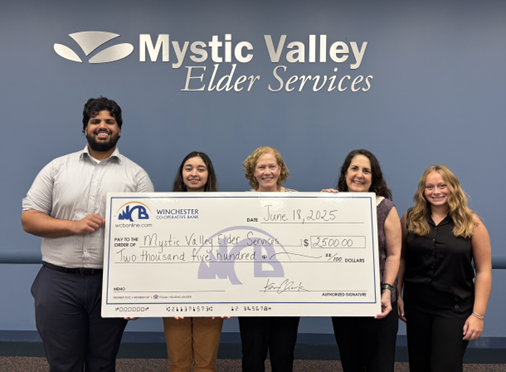5 people holding the big check for a donation at Mystic Valley