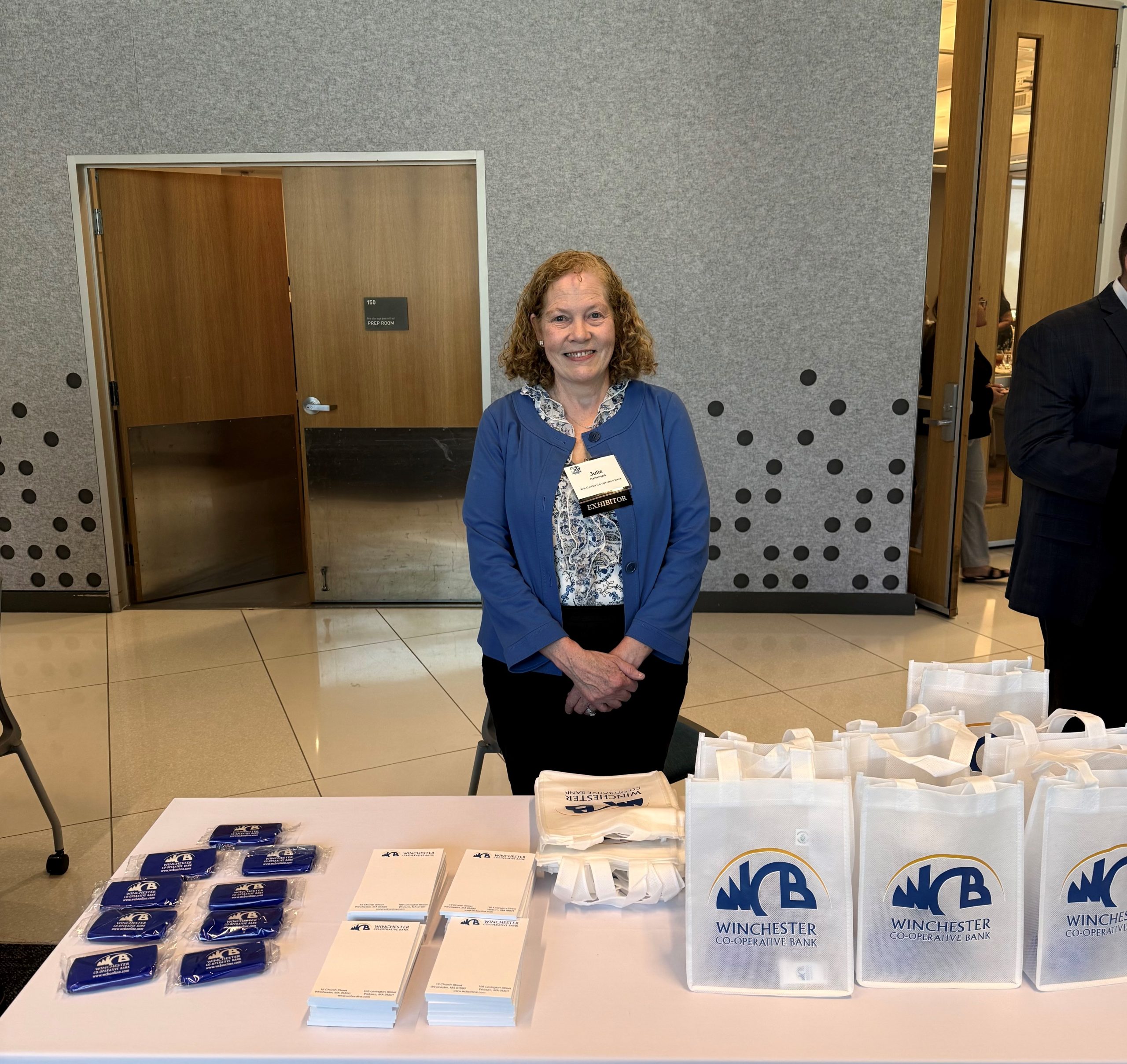Julie behind a table with WCB bags
