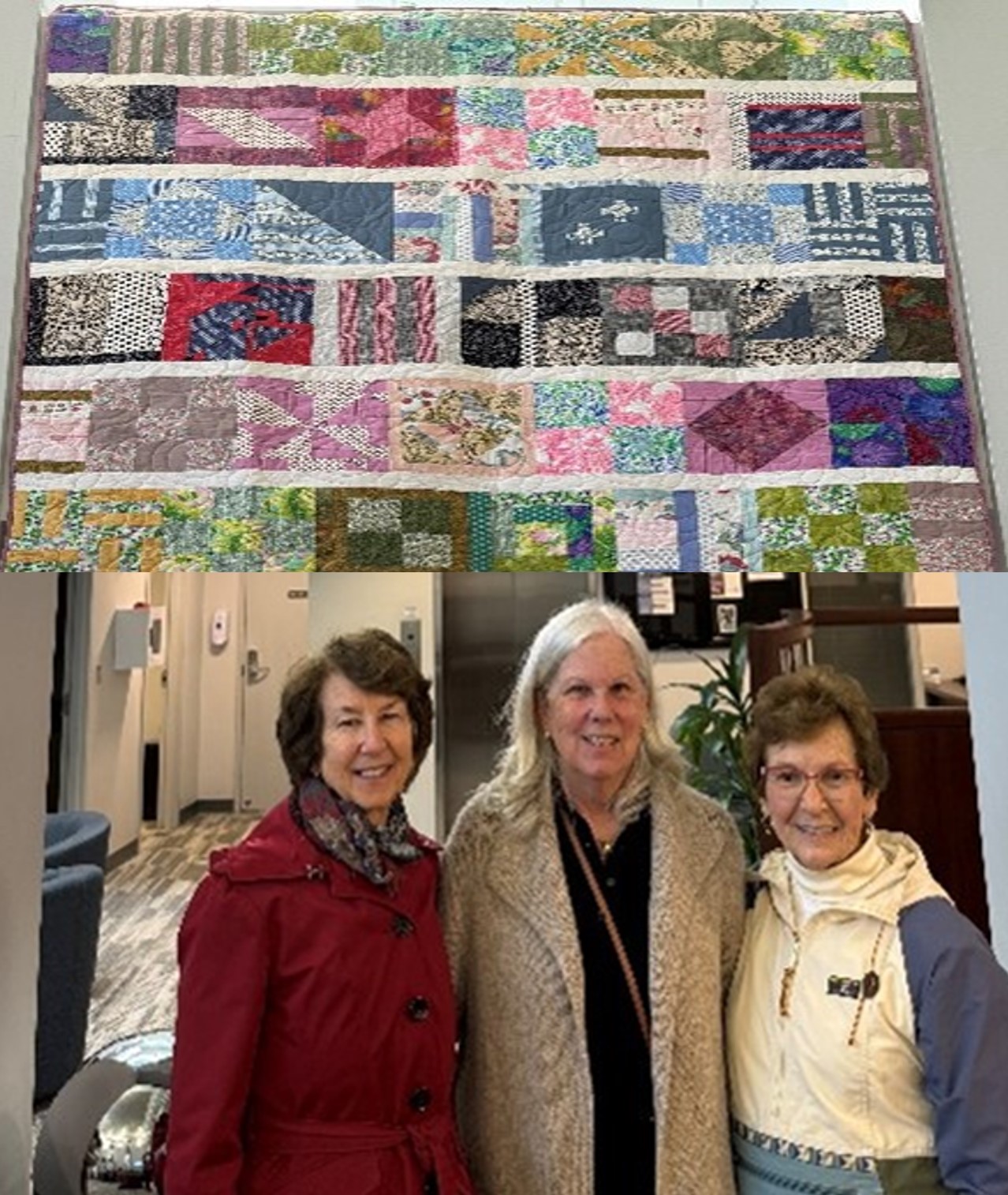 three women standing in front of a quilt with multiple colors