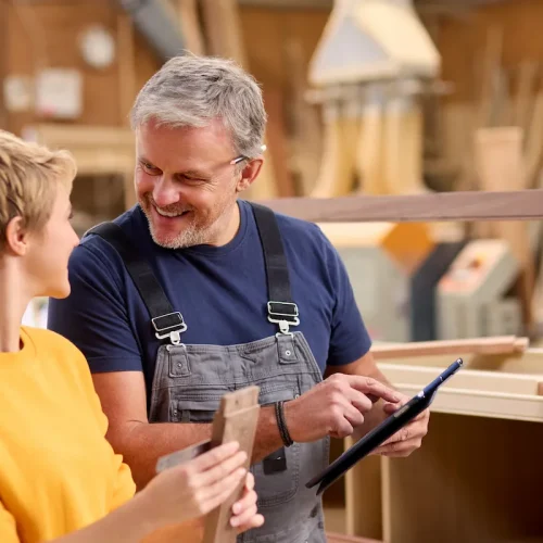 Woodworker looking at business finances on tablet.