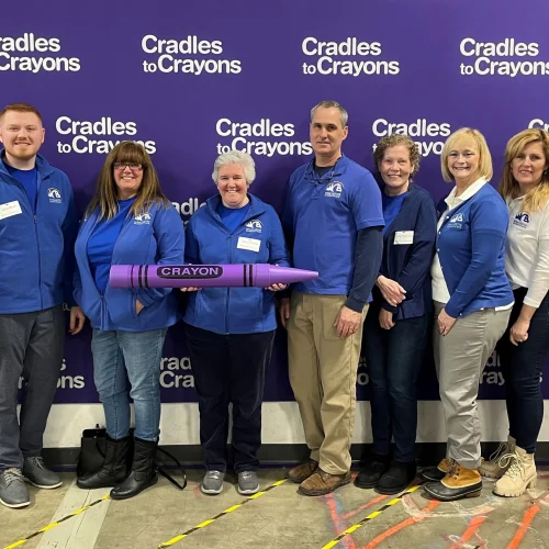 Group of Bankers in front of Cradles for Crayons Backdrop